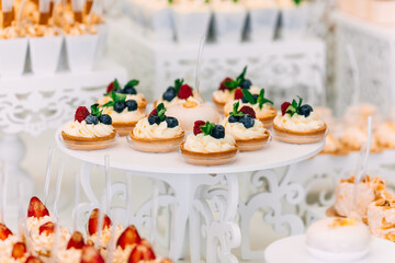 candy bar on wedding reception. baskets decorated with cream and