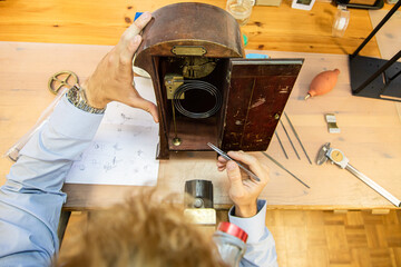 young man assembling mechanical watch. watch production. mans hands