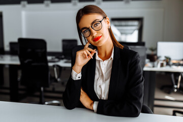 Attractive young business woman sitting at work table in office, business, success concept © Shopping King Louie