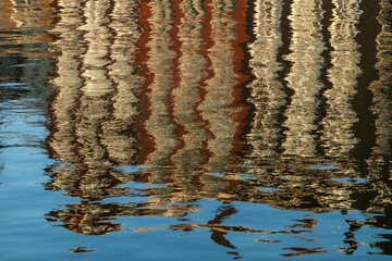 The reflection of the old colorful houses in Amsterdam in the water of the canal in the center. 
