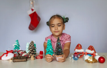 DIY decoration. Girl making a choice between artificial and eco-friendly Christmas tree