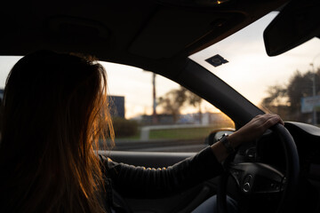 Woman enjoying a car ride on the sunset 