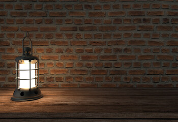 Fototapeta na wymiar old lamp burning on wooden table in front of stone wall