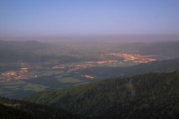 View of city lights in landscape before sunrise from the mountains