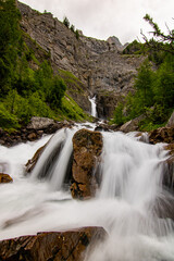 Small waterfalls streaming in green forest in long exposure. water in motion - swiss Alps