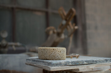 a close up of some nails and a pottery sponge next to some tools of the trade.
