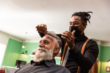 african american barber with mask coronavirus pandemic prevention comb white caucasian male with white beard