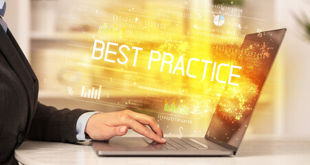 Closeup of businessman hands working on laptop with BEST PRACTICE inscription, succesfull business concept
