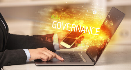 Closeup of businessman hands working on laptop with GOVERNANCE inscription, succesfull business concept