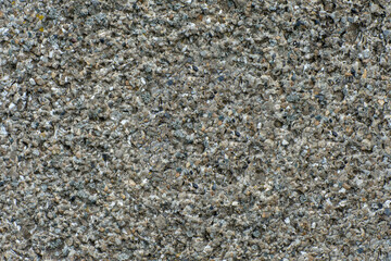 Gray background with a uniform pattern. Fine stone surface. Stone texture. Selective focus.