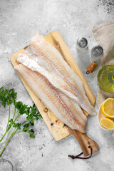 Cod fillet. Raw cod fillet on a chopping Board on a light gray kitchen table. Preparation for...