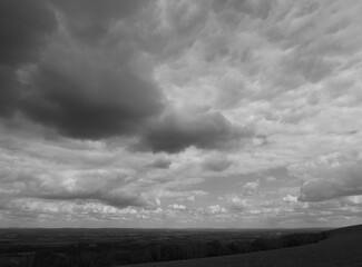 Dramatic dark cloudy sky over the South downs in England in black and white