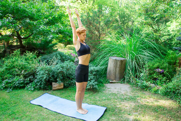 woman doing yoga in the park, young girl doing various wellness exercises, the concept of a healthy...