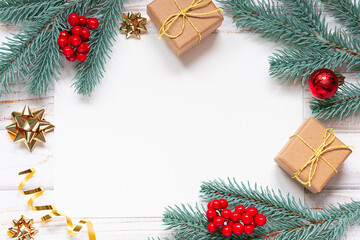 Christmas greeting card mock up with blank sheet of paper, fir tree branches, gift boxes and...