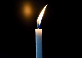 burning candle on black background