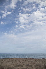 Obraz premium textures of a beach, in the lower third you can see the sand, in the middle the sea and in the upper third the blue sky with white clouds