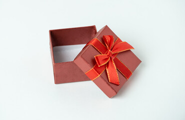 Red gift box with ribbon and bow on white background. For new year, Christmas, Valentine's day and other holiday compositions