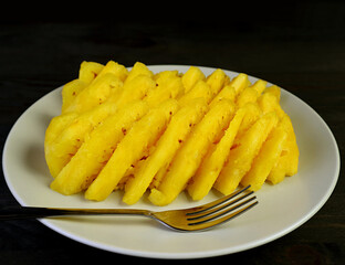 Plate of slices of fresh ripe pineapple for a tasty and healthy dessert