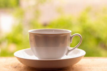 Tea Cup on a wooden windowsill with sunlight. Beautiful natural background.