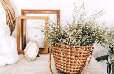 Wicker basket with dried flowers bouquet on the table.