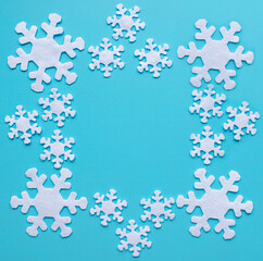 winter composition of white snowflakes on a blue background. frame of snowflakes with copy space
