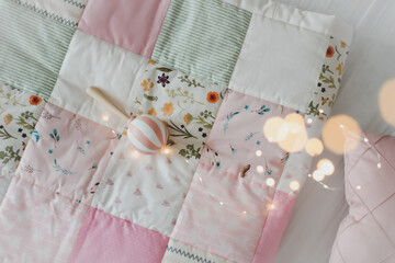 Obraz na płótnie Canvas Cozy baby cot with pink patchwork blanket. Bedding and textile for children nursery. Nap and sleep time