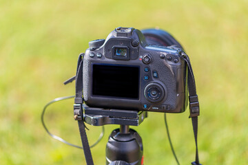 Rear view of a digital camera. The display and rear controls are visible. The camera is mounted on...