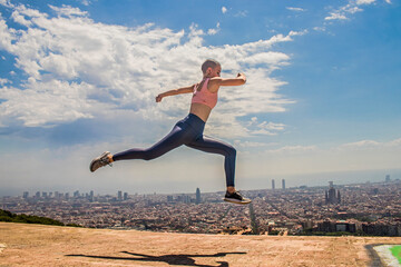 Mujer saltando y haciendo deporte con la ciudad de fondo