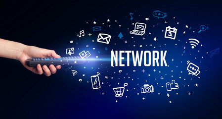 hand holding wireless peripheral with NETWORK inscription, social media concept