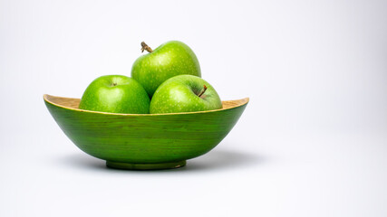 The green plate of green ripe apples on white background. 