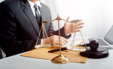 Justice and law concept.Male judge in a courtroom with the gavel, working with, computer and...