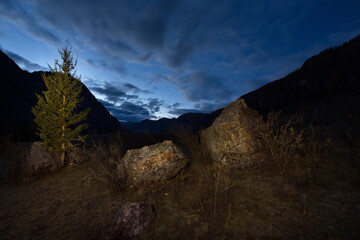 Russia. The South Of Western Siberia. Cloudy full moon in the Chuya river valley along the Chuya highway.