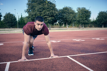 Front view of an athlete starting his career on a track