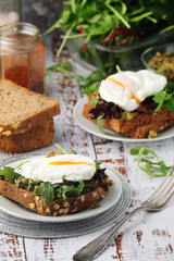 Homemade sandwiches with pesto, green salad and poached eggs