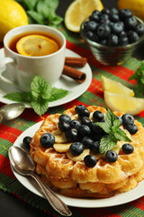 Belgian waffles with blueberry and a cup of tea with lemon