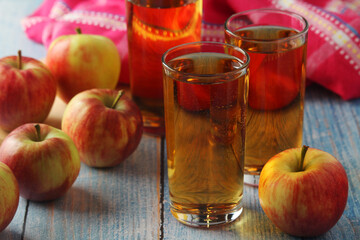 Glasses with apple juice and ripe apples