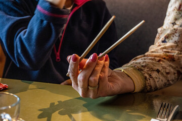 Obraz premium female hand with chinese chopsticks