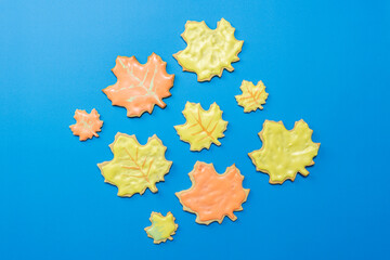 Sweet homemade leaf cookie with icing isolated on dark blue background flat lay composition.