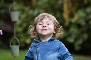 Close Up Portrait of a little 18 Month Old Girl with  Big Blue Eyes and Curly Hair, a girl Playing Outside, Funny Face Expression, Happy baby