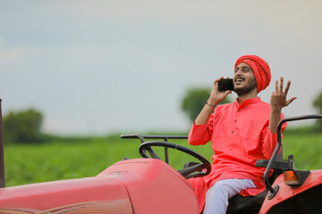 Naklejka premium young indian farmer talking on smartphone