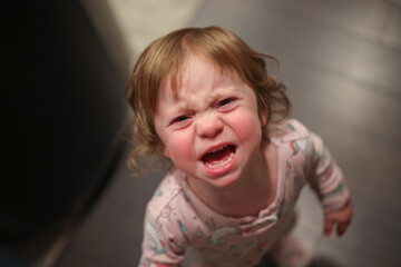 Close up Portrait of cute 18 month Old Crying Toddler Girl with Big Blue Eyes