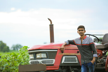 Young indian with tractor at agriculture field