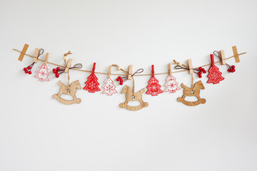 Christmas garland made of wooden baubles and red berries on white background