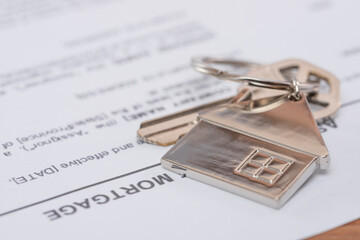 Real estate mortgage approved loan document with keys with home shaped keychain. Mortgage, investment, real estate, property and new home concept. Close-up view.