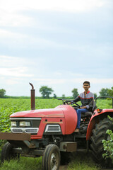 Young indian with tractor at agriculture field
