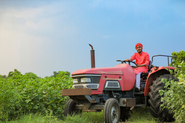 Indian farmer working with tractor at field