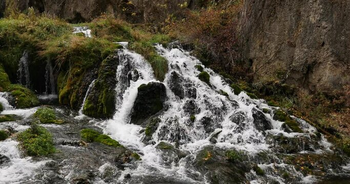 Mountain waterfall cascade moss forest 4K. Beautiful clear water high mountain stream from springtime snow melt and natural springs. Moss with rocks form waterfalls. Scenic nature environment.