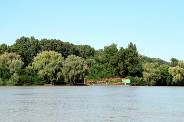 Barco grúa trabajando a orillas del río Danubio en Rumanía. Barco grúa en el delta del Danubio que trabaja cargando troncos para su transporte.