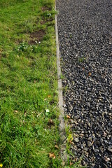 a straight line between grass and gravel