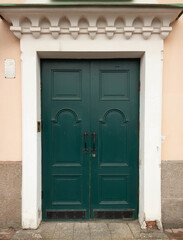 Fototapeta na wymiar Emerald green old door in a light house